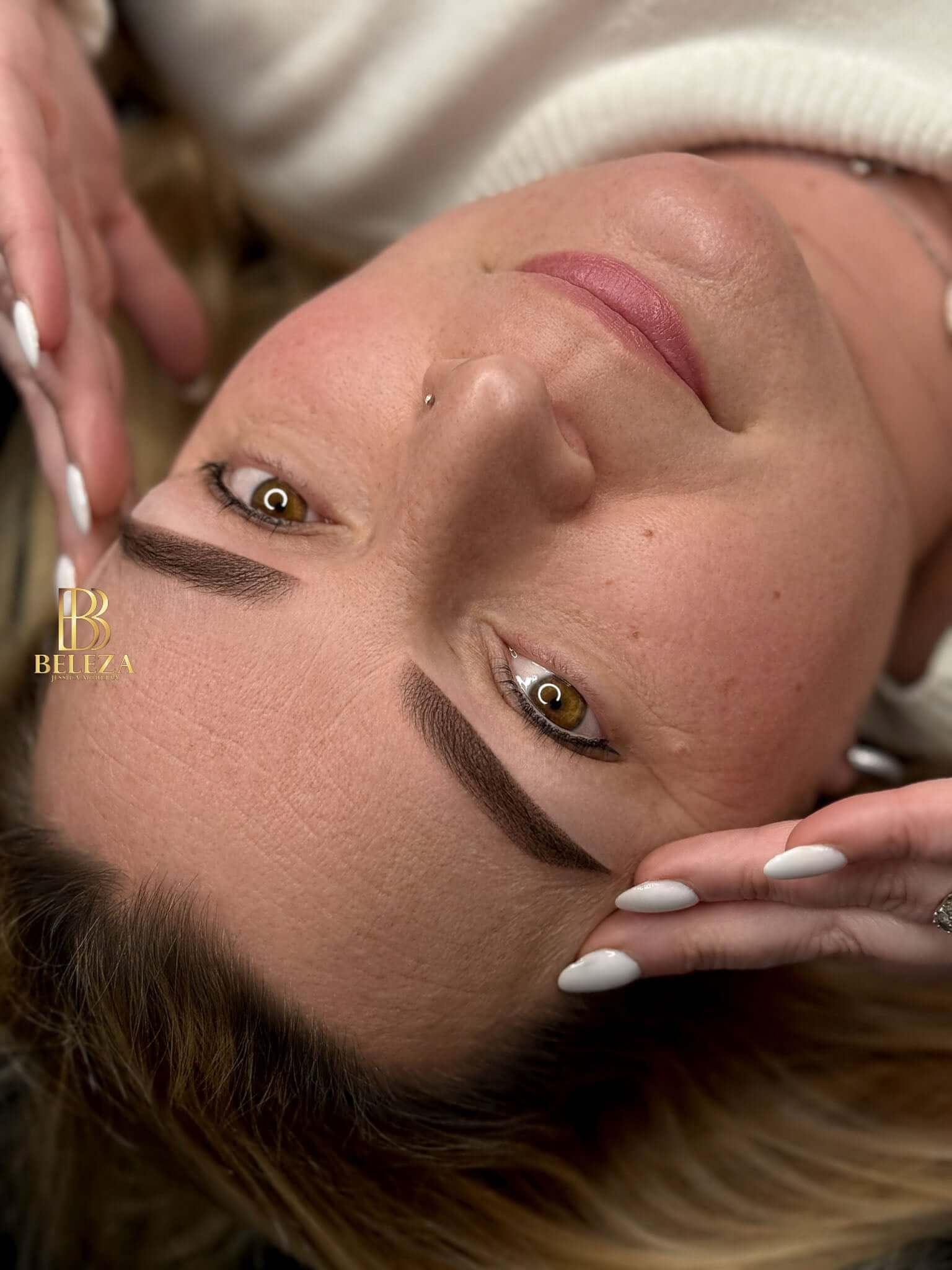 Close-up of a woman with stylish eyebrows and a serene expression, showcasing natural beauty and elegance.
